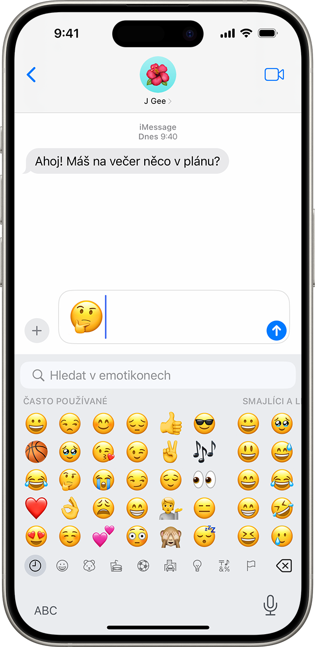 Obrazovka iPhonu zobrazující konverzaci Zpráv s emotikonem zamyšleného obličeje v textovém poli.